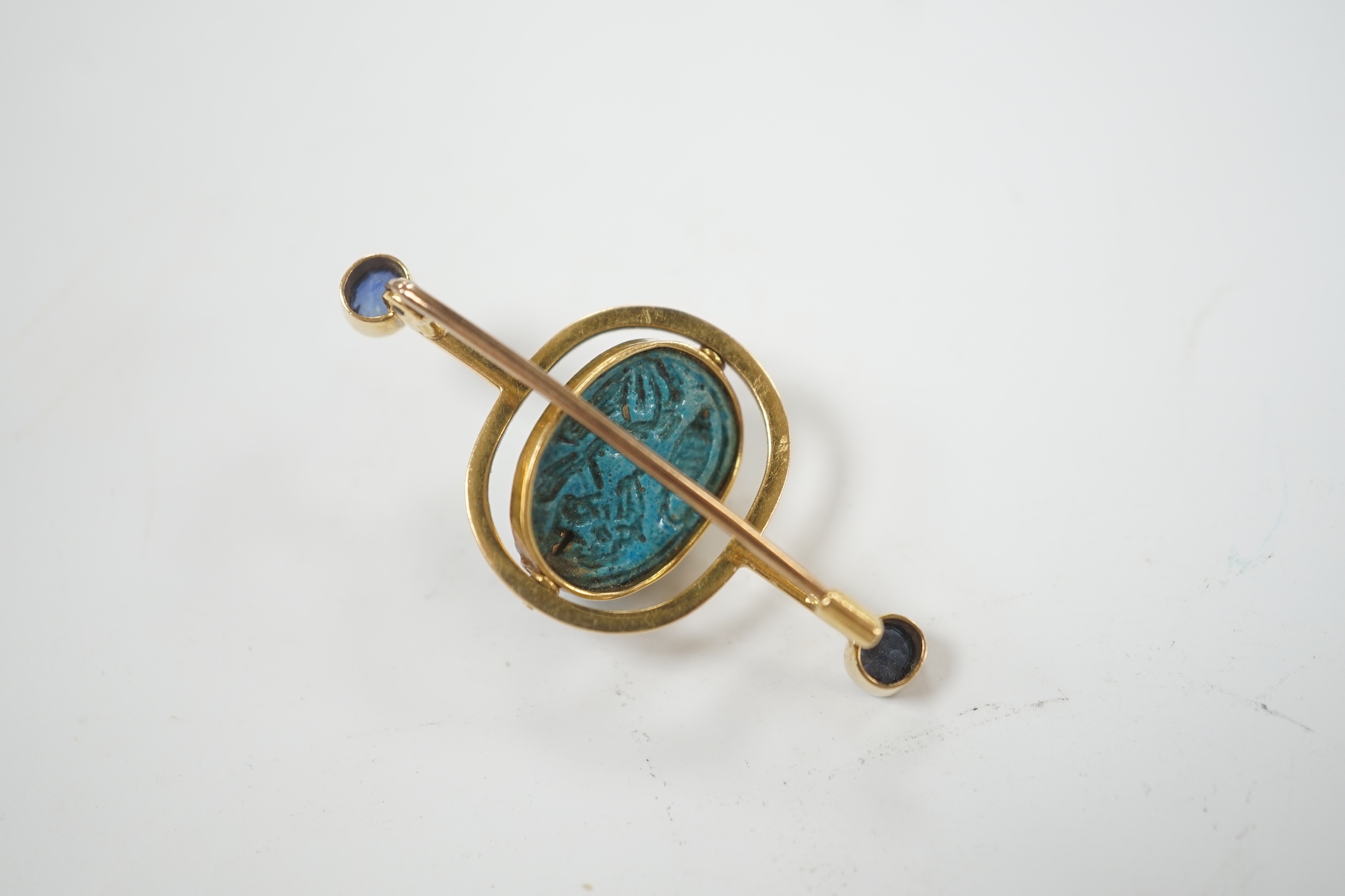 A yellow metal and two stone sapphire set swivelling scarab bar brooch, 41mm, gross weight 5.7 grams.